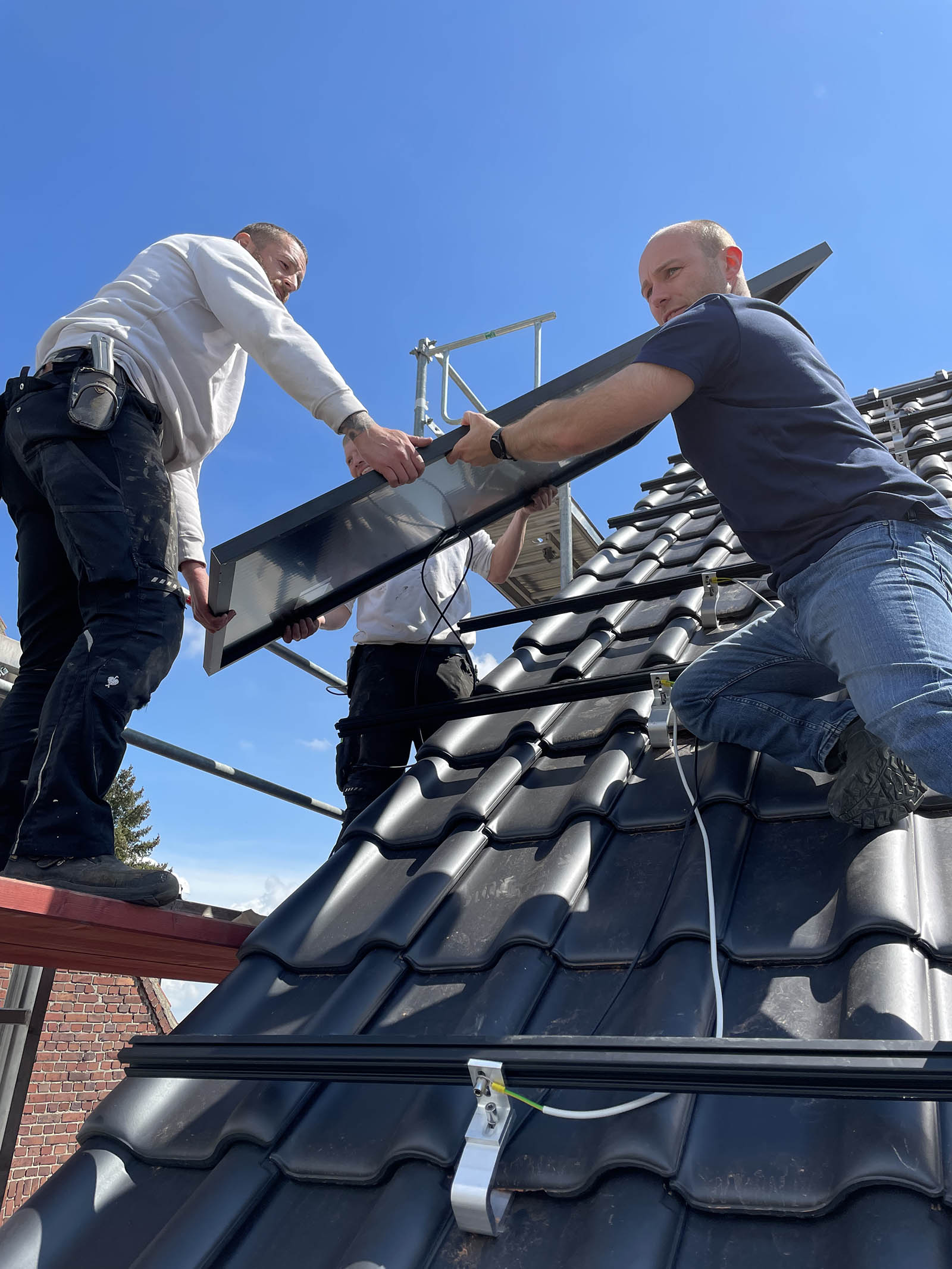 Handwerker bei der Montage von Solarmodulen auf dem Dach